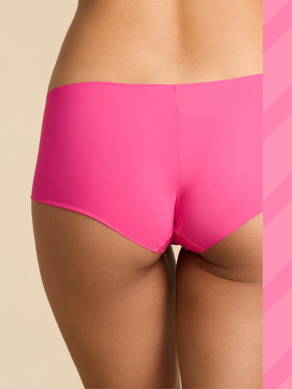 Person wearing bright pink underwear on a beige background