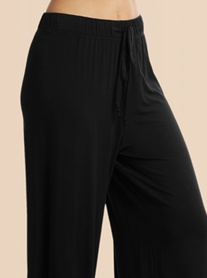 Black wide-leg pants on a beige background