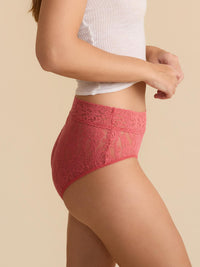Person wearing red lace underwear against a beige background
