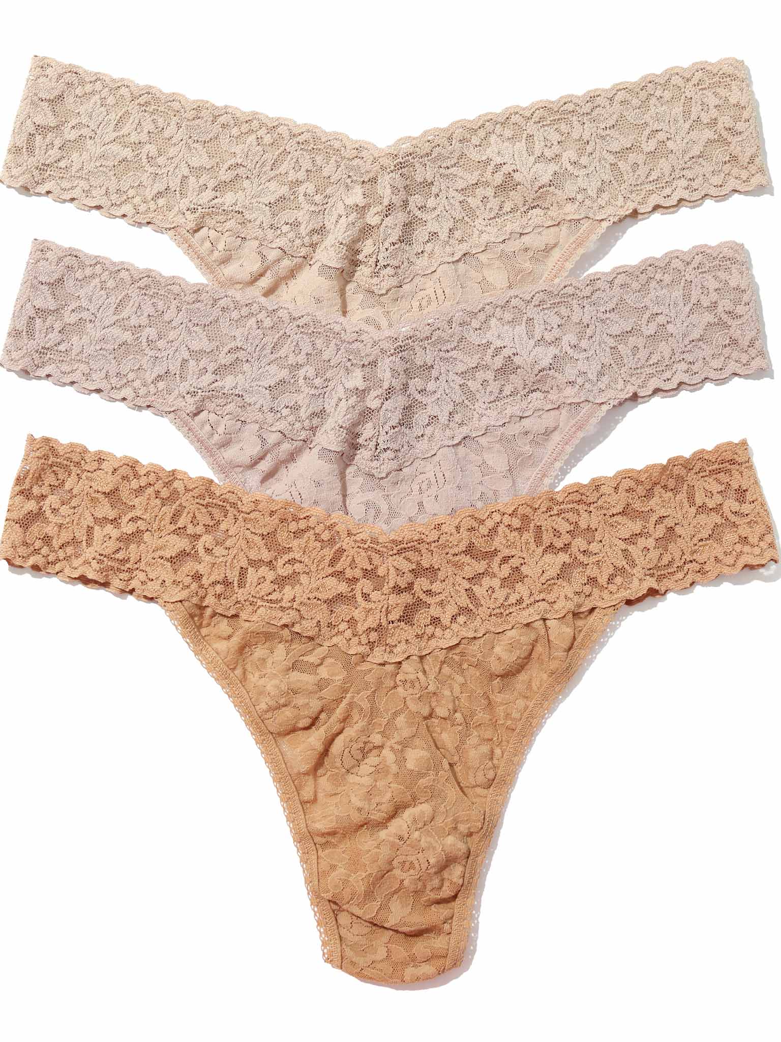 Thre pairs of lace thongs in chai, taupe and suntan on a white background