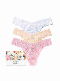 Three pairs of lace panties in white, beige, and pink with a floral gift box on a white background.