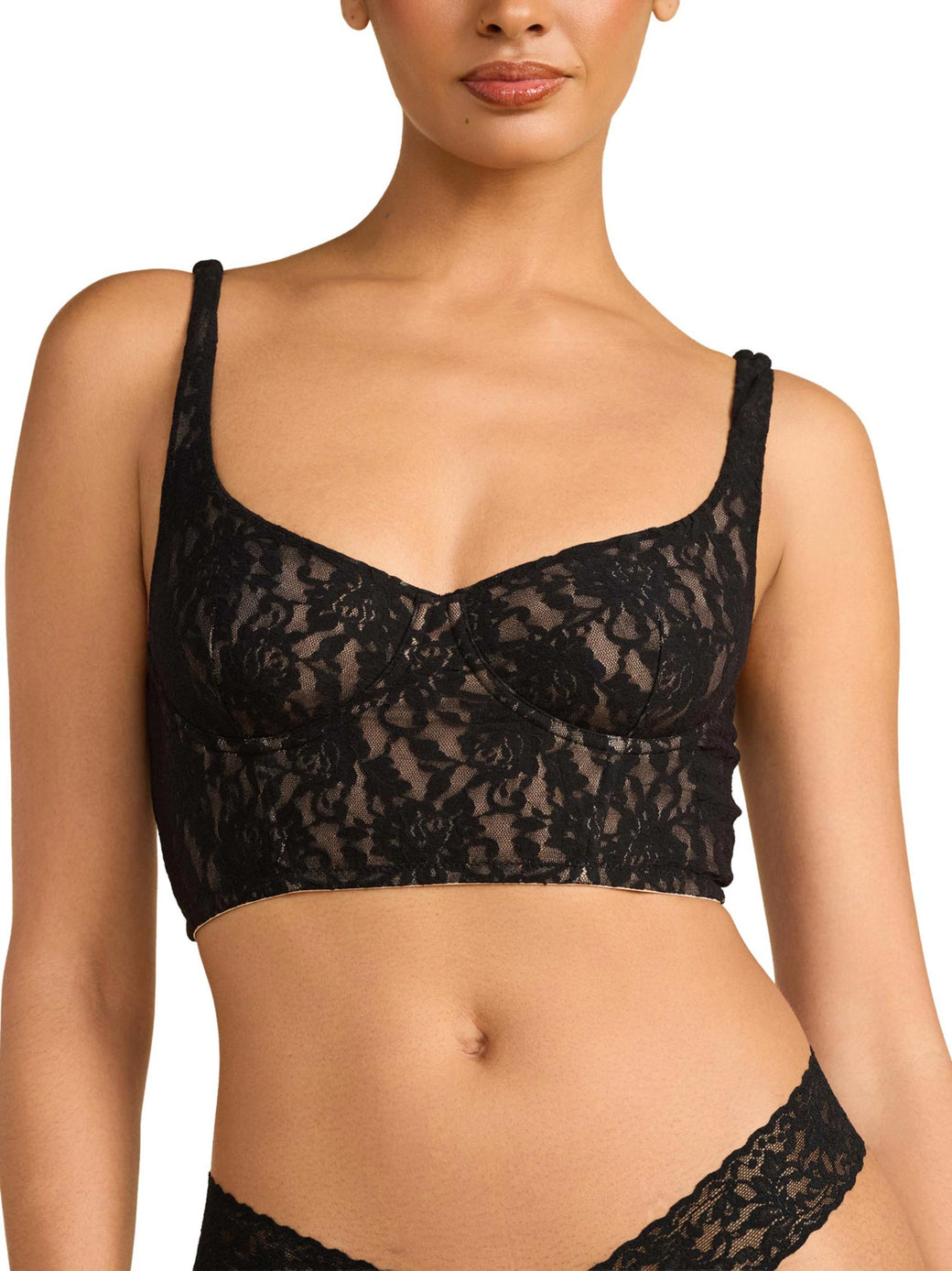 Black lace bra worn by a model on a plain background