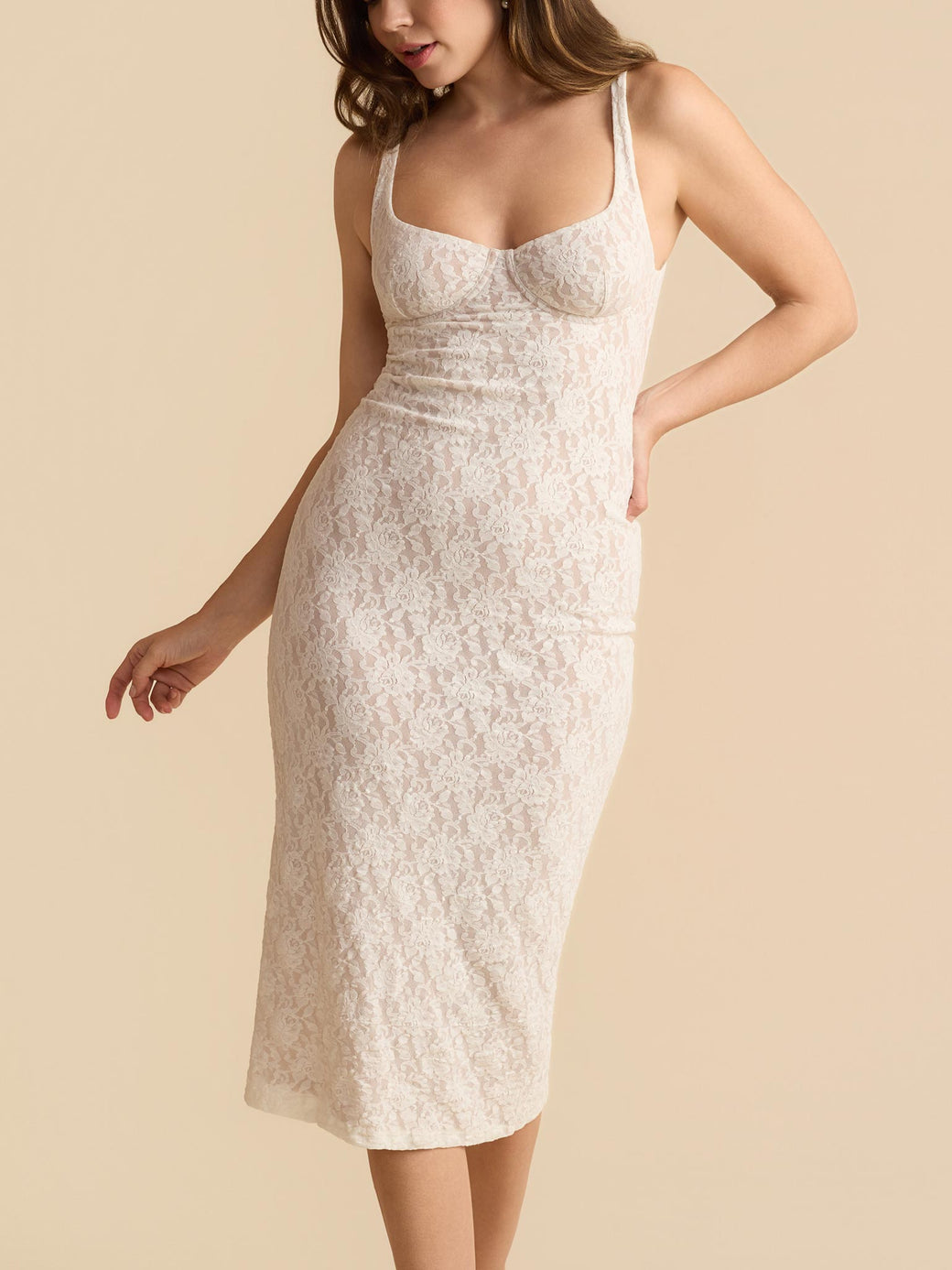 Woman wearing a white lace dress against a beige background