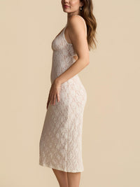 Woman wearing a lace dress against a beige background