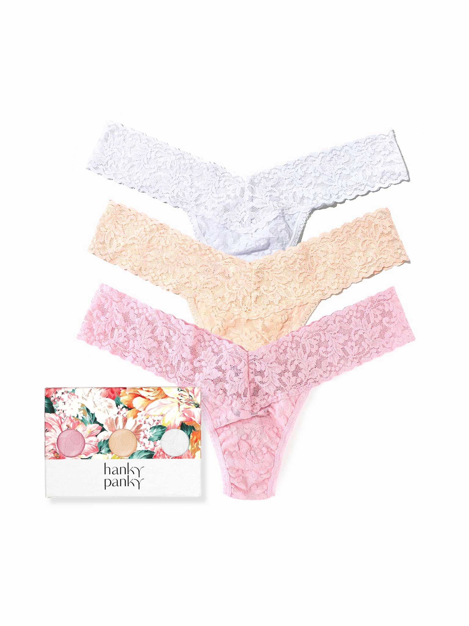 Three lace panties in white, beige, and pink with a floral box labeled 'hanky panky' on a white background.