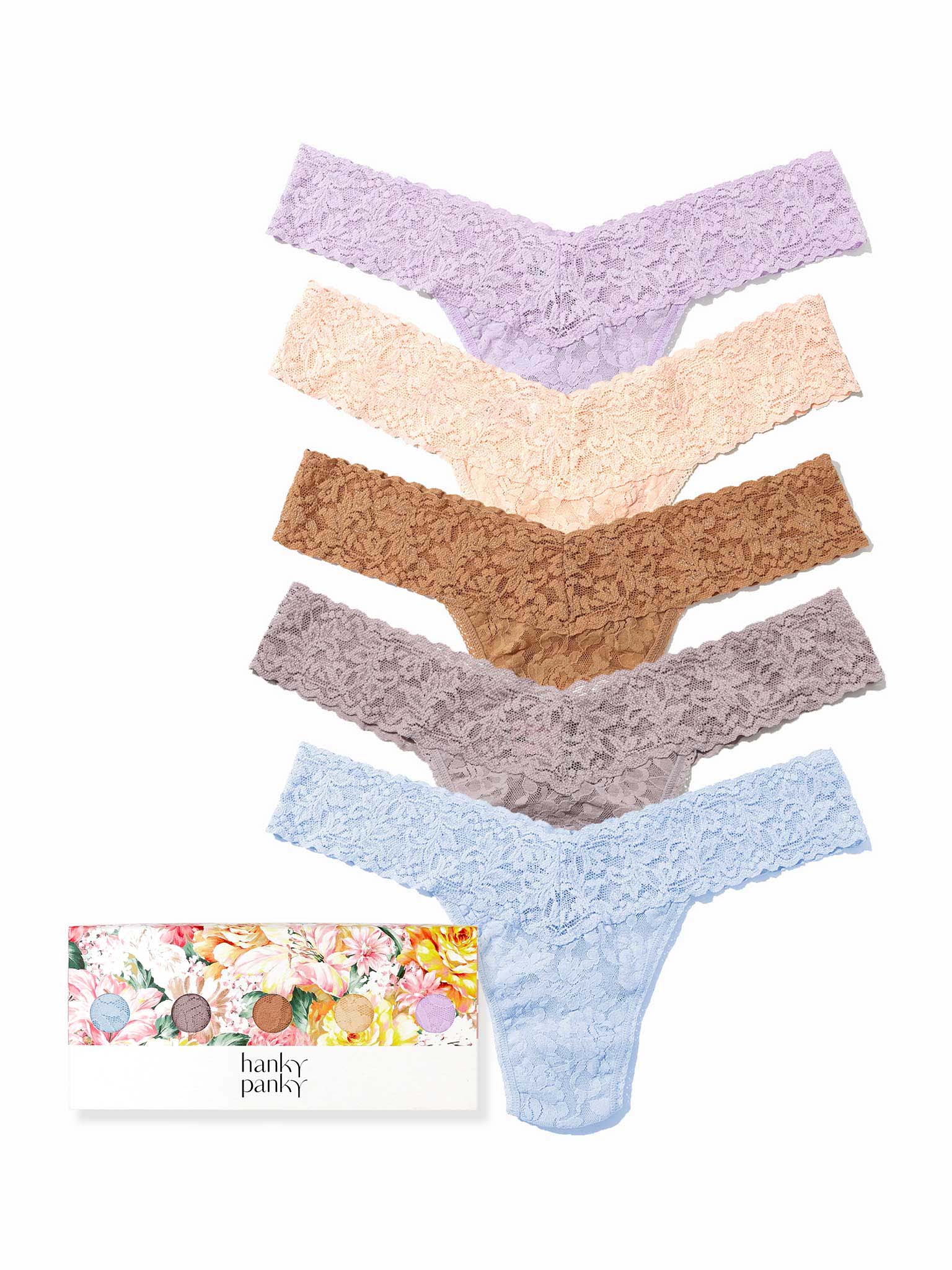 Set of five women's underwear in various colors with a floral-patterned box in the background.