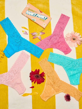 Colorful lace underwear on a yellow and white striped background with flowers.