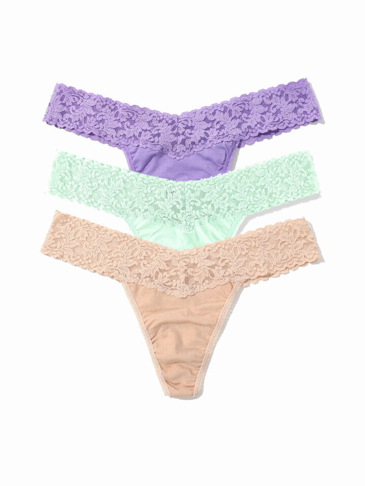 Three pairs of lace-trimmed panties in purple, green, and beige on a white background.