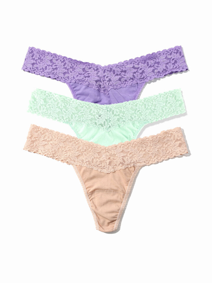 Three pairs of lace-trimmed panties in purple, green, and beige on a white background.
