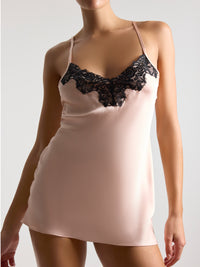 Pink nightgown with black lace details on a plain background