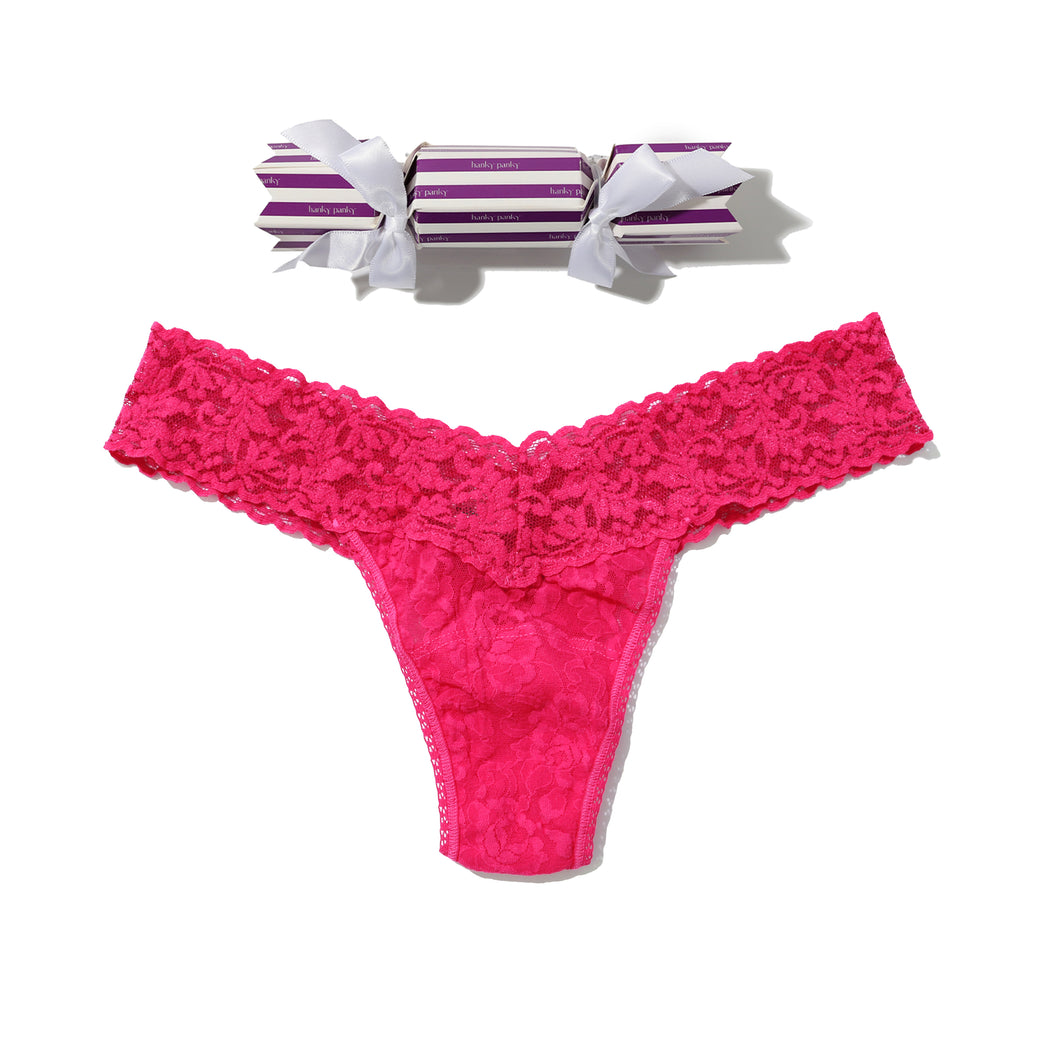 Pink lace thong with striped candy on a white background