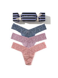 Set of three pairs of lace underwear in blue, pink, and red with a striped candy cracker on a white background.