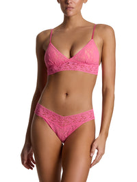 Woman wearing a pink lace lingerie set on a white background