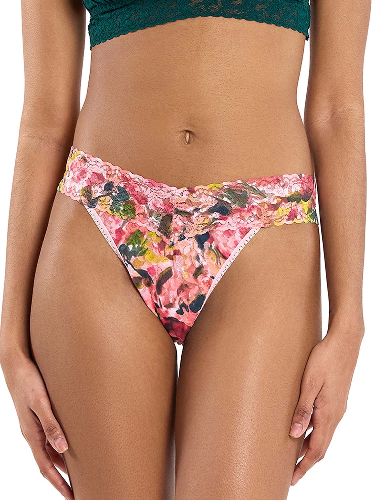 woman wearing floral pink lace thong standing in front of white background