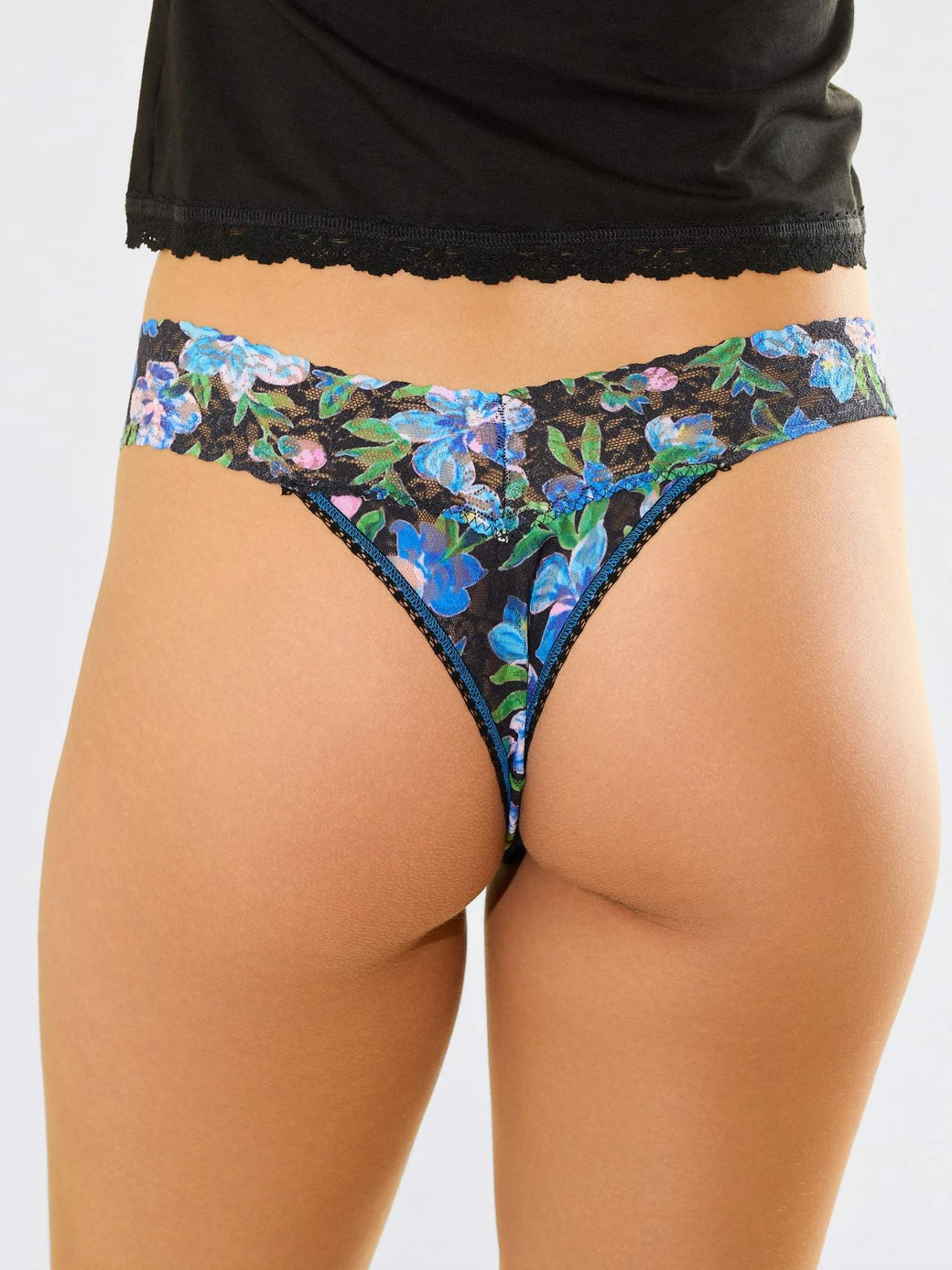 Model facing back in Printed Signature Lace® Low Rise Thong Ocean Blooms Black with black cami
