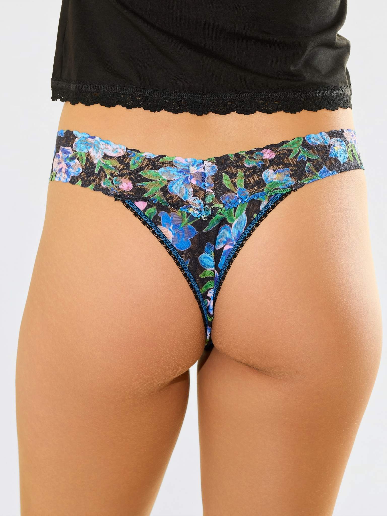Model facing back in Printed Signature Lace® Low Rise Thong Ocean Blooms Black with black cami
