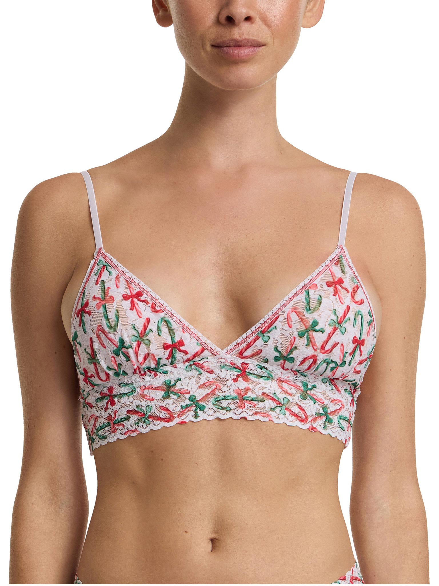 Woman wearing a bra with a festive candy cane pattern on a white background
