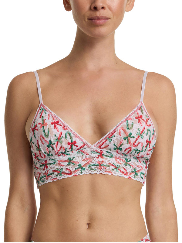 Woman wearing a bra with a festive candy cane pattern on a white background