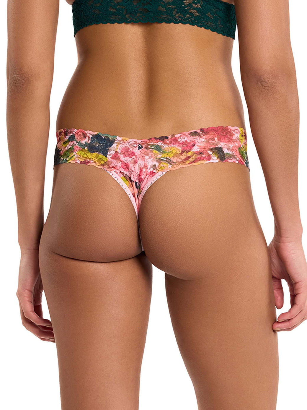 woman wearing floral pink lace thong facing backwards on white background