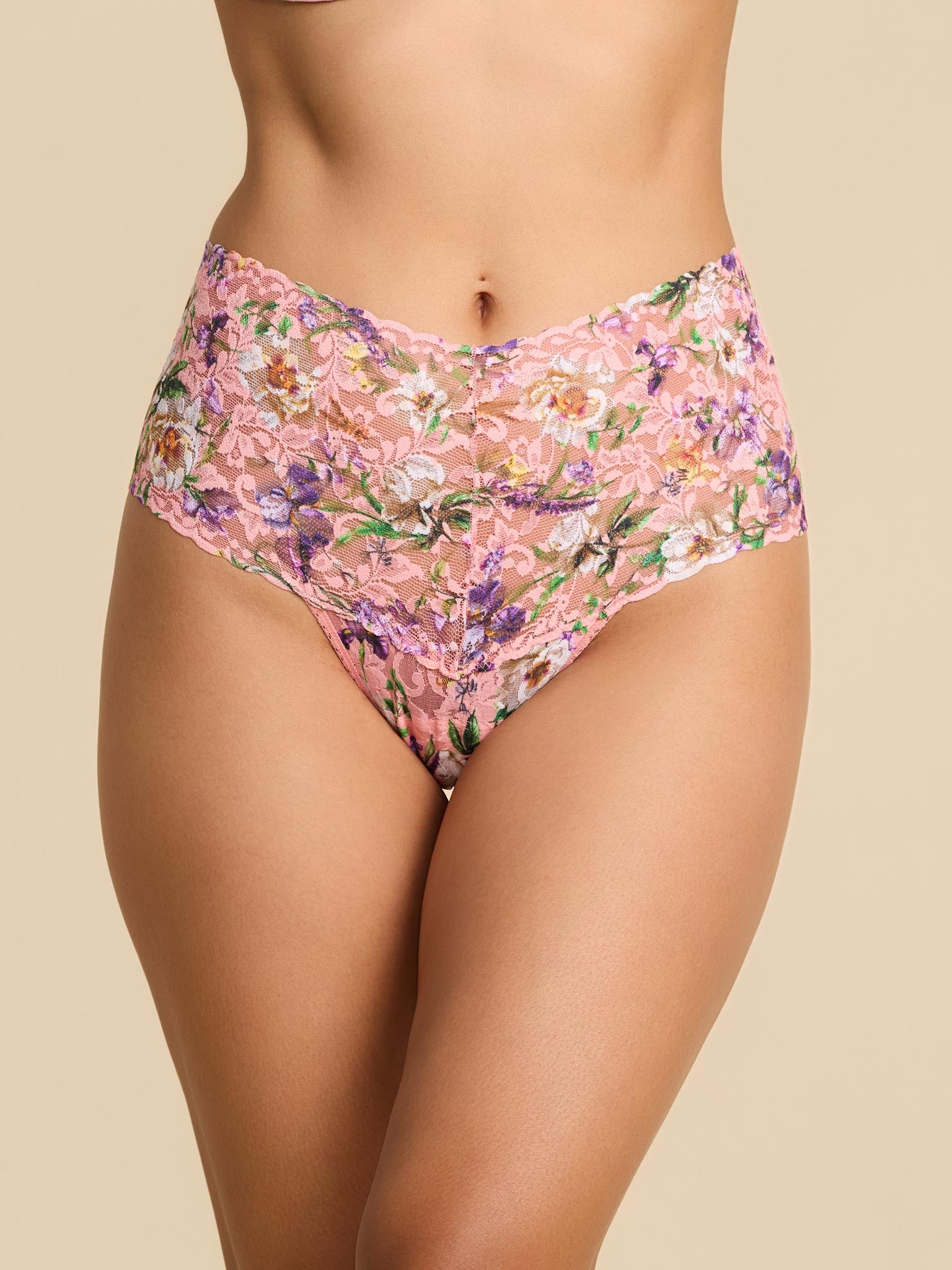 Floral-patterned high-waisted bikini bottom on a beige background