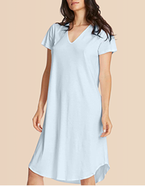 Woman wearing a light blue dress against a beige background