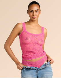 Woman wearing a pink tank top with lace details on a beige background