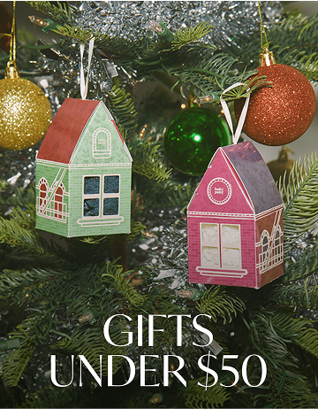 Two small house-shaped ornaments on a Christmas tree with text 'Gifts Under $50'.