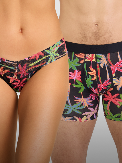 Tropical palm tree patterned underwear on male and female models matching each other to be color coordinated on a neutral background